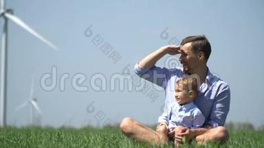 男孩向坐在草地上的父亲展示了一些东西